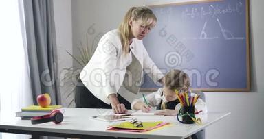 中年白种人家庭教师站在女学生旁边写作业本。 私人教师和勤奋的孩子